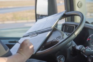 Truck driver taking notes in rig